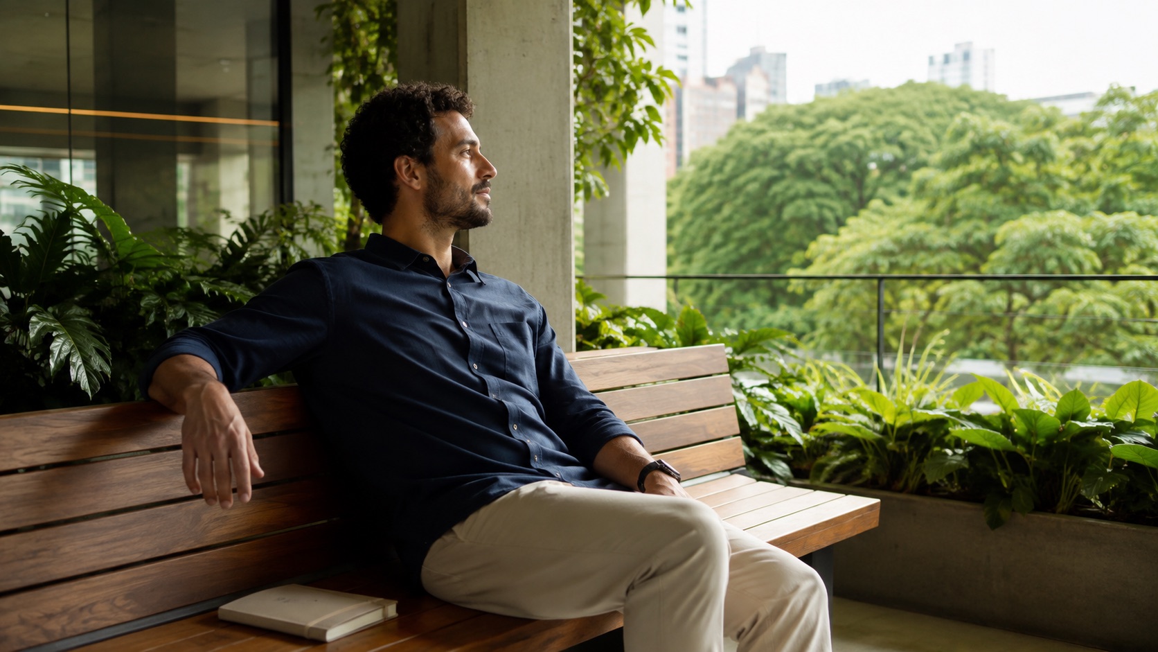 Homem sentado em um terraço observa árvores durante uma pausa acordada